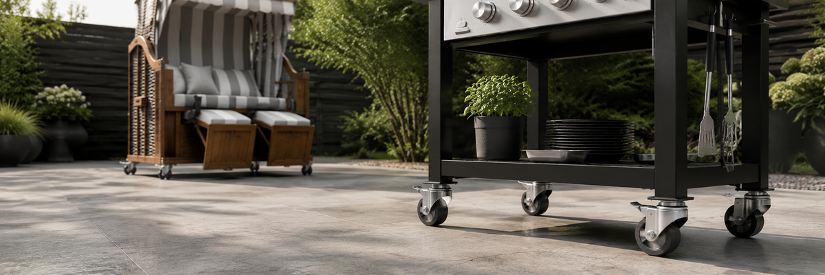 Ein Grillwagen und ein gestreifter Stuhl auf einer Terrasse, im Hintergrund stehen Topfpflanzen.